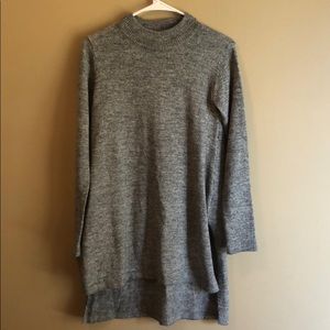 a long high neck sweater with a slit on the side